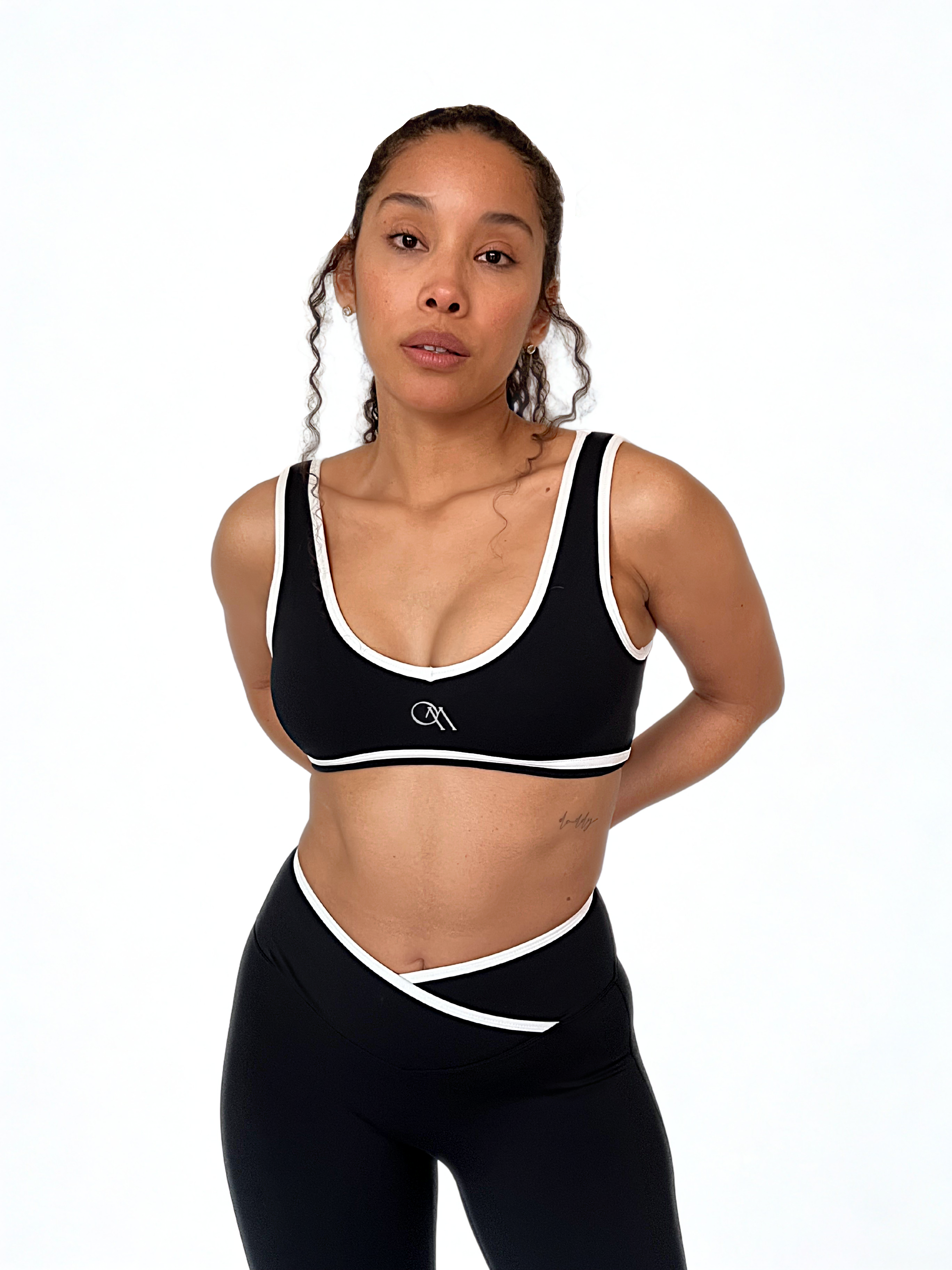 top deportivo negro para mujer con soporte medio, ideal para gimnasio